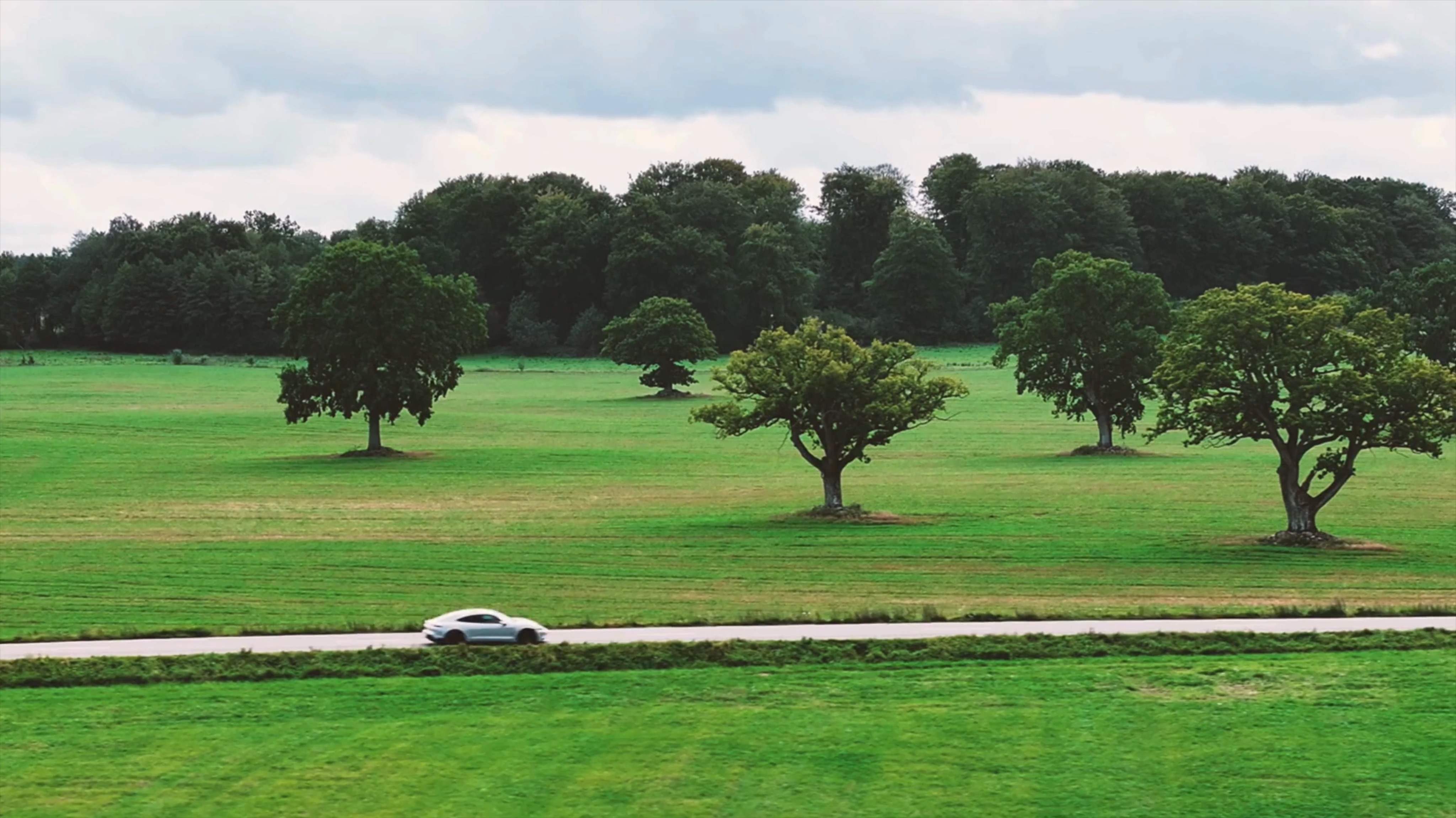 Porsche Driving Through Green Fields
